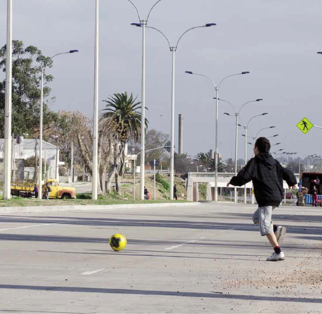 Niño cruzando la calle detrás de una pelota